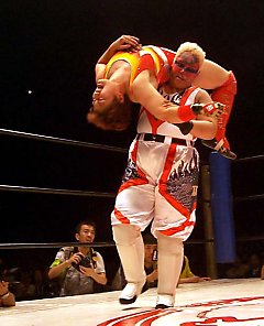 Aja holds Satomura in a Canadian backbreaker from Nikkan Sports
