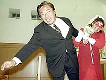 Kyoko prevents Kuroda from running away during their wedding rehersal Nikkan Sports